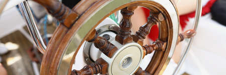 Wooden vintage steering wheel on a yacht close-upの写真素材