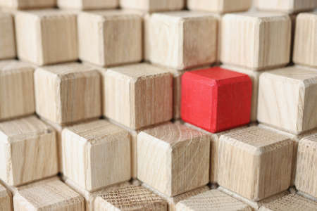 Wooden cubes of beige color in middle of red stands in pyramidの写真素材