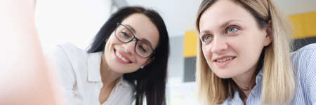 Two young women are sitting at laptopの写真素材