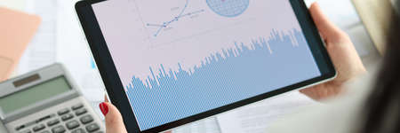 Female hands hold tablet with business indicatorsの写真素材
