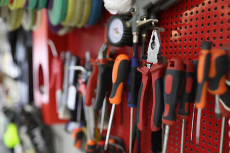 Many working tools hanging on wall in workshop closeup