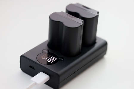 Closeup of black camera battery charger with cableの写真素材