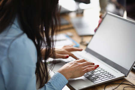 Woman sitting at the table and working at laptopの写真素材
