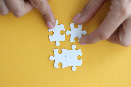 Image of businesswoman connecting elements of white puzzle closeupの写真素材