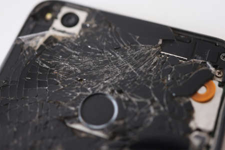 Closeup of black broken mobile phone in workshopの写真素材