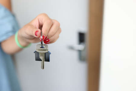 Female hand holds key from house closeup