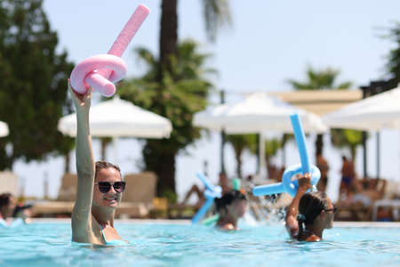 Young women during water aerobics classes in hotel pool closeup