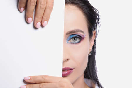 Model with colored eye makeup, perfect half face skin with white card templateの写真素材