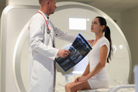 Male doctor explaining to female patient result of MRI examination in clinicの写真素材