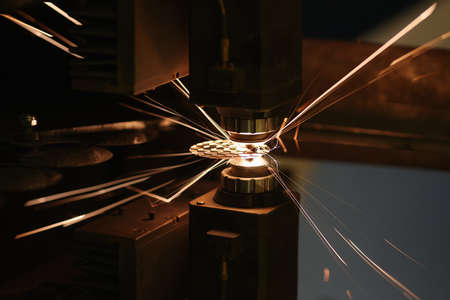 Sparks from automatic laser cutting or engraving of parts closeup