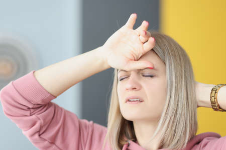 Portrait of young tired woman with headache closeupの写真素材