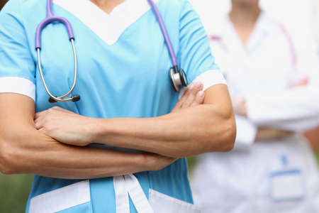 Two doctors stand confidently with folded hands closeupの写真素材