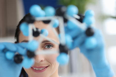 Scientist looks at model of mockup made of molecules closeupの写真素材