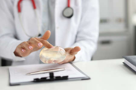 Doctor surgeon holding breast silicone implant in clinic closeupの写真素材