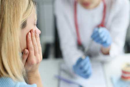 Woman at doctor appointment with toothache closeup