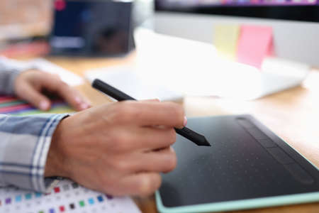 Female hand with stylus on graphics tablet closeupの写真素材