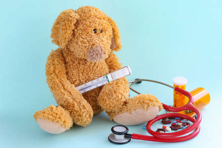 Children toy with thermometer, stethoscope and medical pills on blue backgroundの写真素材