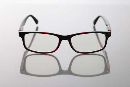 Modern stylish glasses with dark frames on tableの写真素材