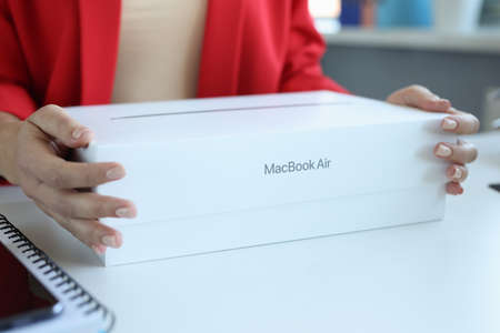 Minsk, Belarus, October 11, 2021:In female hands box from MacBook Air laptopのeditorial素材
