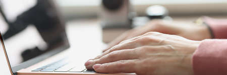 Female hands typing on laptop keyboard closeupの写真素材