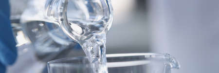 Water is poured from transparent bottle into glass