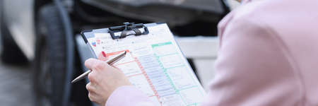 Insurance agent is filming damage to car after accidentの写真素材