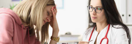 Young woman under stress from medical diagnosis at clinic appointment