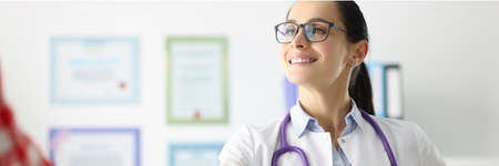 Smiling female doctor shakes hands with patient in hospitalの写真素材