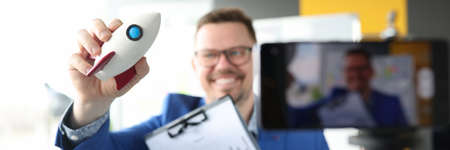 Male blogger holds rocket and graph with financial indicators and records training videos