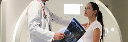 Male doctor explaining to female patient result of MRI examination in clinicの写真素材