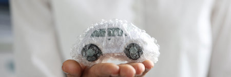 Female agent is holding toy car packed in bubble plastic bag