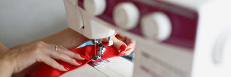 Woman seamstress sews a seam on a sewing machine