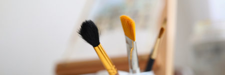Painting brushes and easel stand in the roomの写真素材