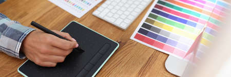 Graphic designer works on computer and selects color schemes