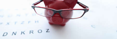Red pig in glasses stands on ophthalmological table closeupの写真素材