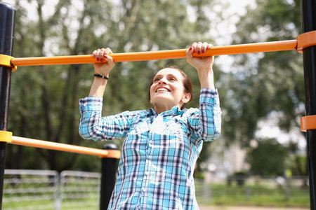 Woman hanging on horizontal bar and smiling