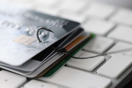 Fishing hook with credit cards on keyboard closeupの写真素材