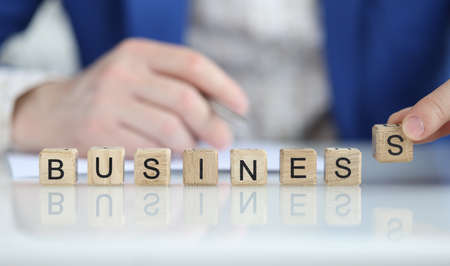 Person puts letter s in word businessの写真素材