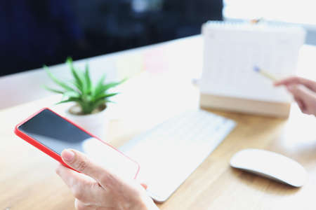 Smartphone in hand of people at workplace