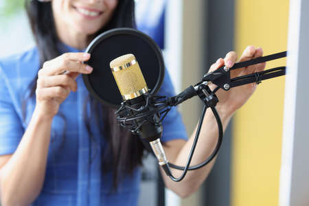 Radio presenter works adjusts microphone, prepares speak before recording podcast, and lives on social networksの写真素材