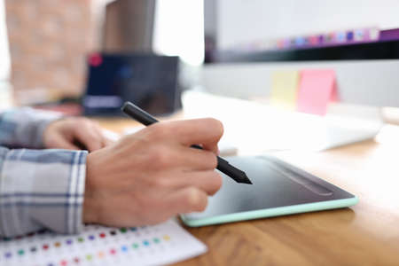 Stylus in hand from graphics tablet closeupの写真素材