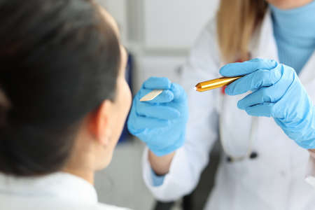 Lady having throat examined with special tool and flashlight, medical support and help in clinic