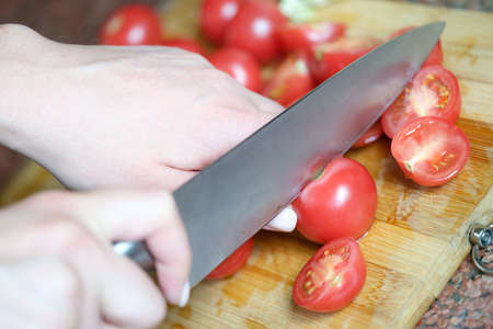 Chef is cutting tomatoes in kitchen and vegetarianism