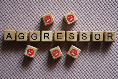 Text aggressor on cubes and angry emoticons closeupの写真素材