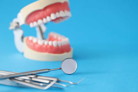Dental tool and dental open jaw on blue background
