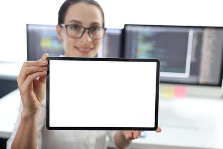 Woman is holding tablet with white screen. at workの写真素材