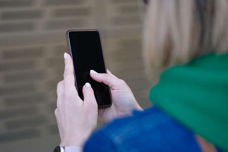 Woman holds stylish smartphone in hands closeupの写真素材