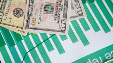 Business report in charts and cash closeup