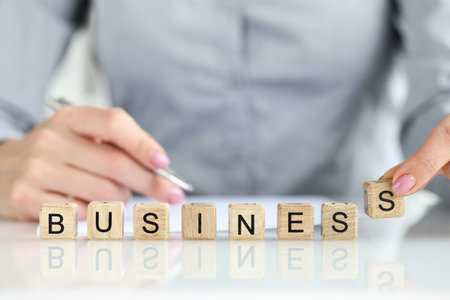Businesswoman collected business word with wooden cubesの写真素材