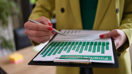 Businesswoman holds financial report and analytics in chartsの写真素材